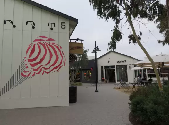 Upscale, colorful plaza in farmhouse style, with modern cafes. Kids climb on a huge log. The fire pit is fantastic at night, surrounded by eucalyptus trees.