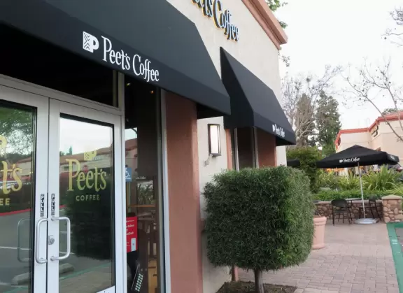 Small shopping plaza with pretty clock tower and landscaped stream.