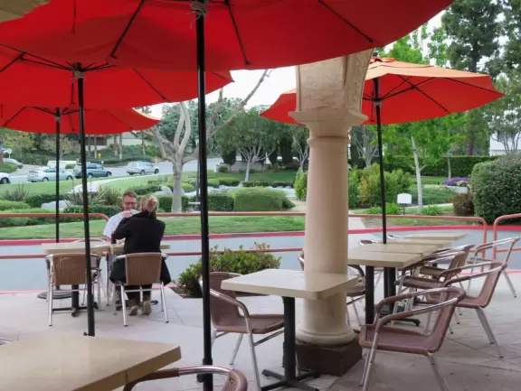 Small shopping plaza with pretty clock tower and landscaped stream.