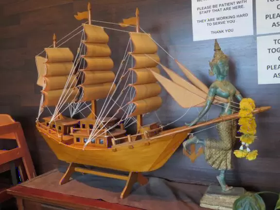 Small shopping plaza with pretty clock tower and landscaped stream.