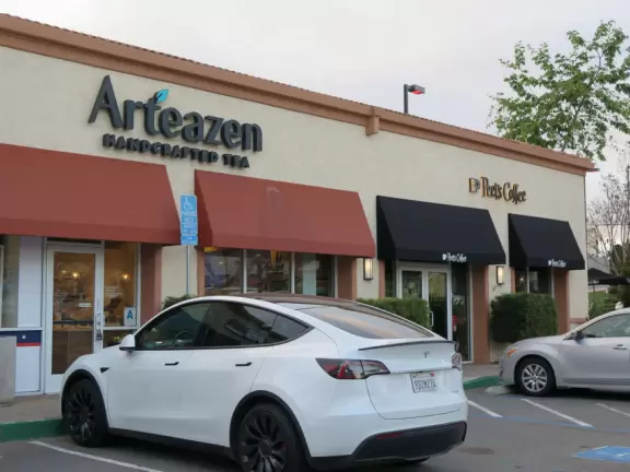 Small shopping plaza with pretty clock tower and landscaped stream.