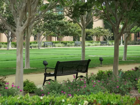 Restaurants with magical gardens, shops, fountain, open grassy areas, historical salmon-pink Spanish Revival architecture at a former naval training center.