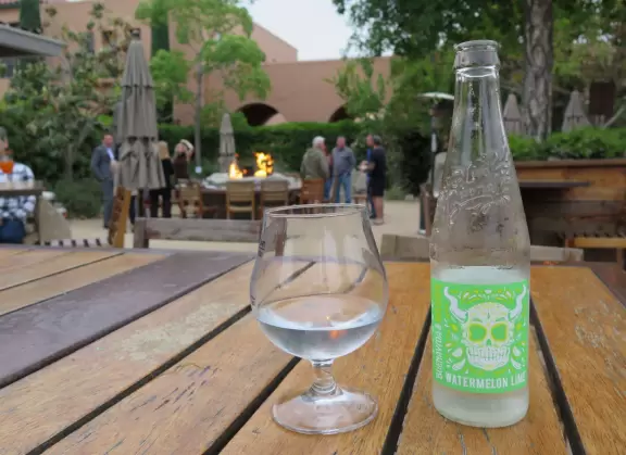 Restaurants with magical gardens, shops, fountain, open grassy areas, historical salmon-pink Spanish Revival architecture at a former naval training center.