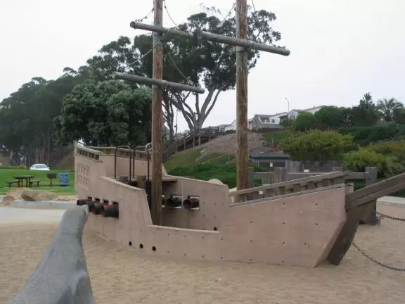 Cement ship playground with logs to climb, seal, dolphin, whale's tail and giant octopus sculptures, picnic tables, and an amazing view of Morro Rock and the inlet.