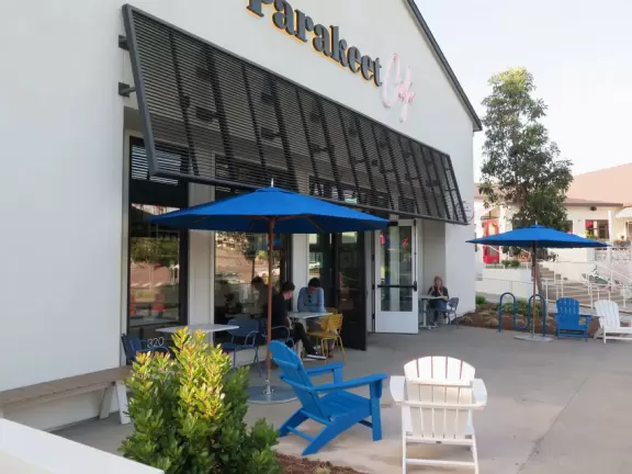 Upscale, colorful plaza in farmhouse style, with modern cafes. Kids climb on a huge log. The fire pit is fantastic at night, surrounded by eucalyptus trees.
