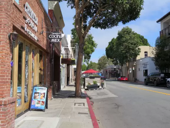A main street of late 19th century storefronts, popular cafes, and a hip college scene. Recently, suffering an epidemic of homelessness relating to mental health problems.