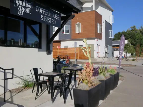 Trendy area with coffee shop, beer garden, wine bars, and cider bar, in industrial-style architecture with murals.