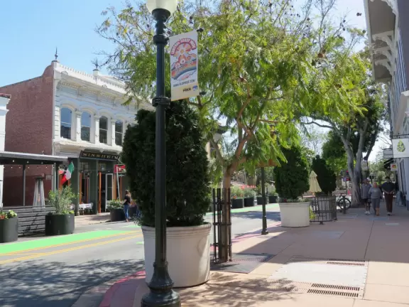 A main street of late 19th century storefronts, popular cafes, and a hip college scene. Recently, suffering an epidemic of homelessness relating to mental health problems.