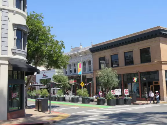 A main street of late 19th century storefronts, popular cafes, and a hip college scene. Recently, suffering an epidemic of homelessness relating to mental health problems.