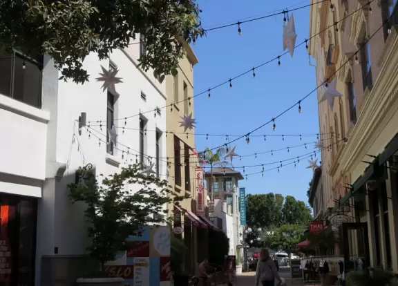 A main street of late 19th century storefronts, popular cafes, and a hip college scene. Recently, suffering an epidemic of homelessness relating to mental health problems.