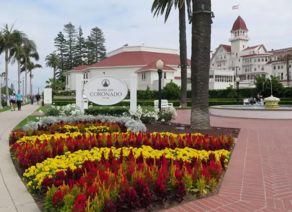 Historic resort with red turrets on foggy beach of fine white sand.