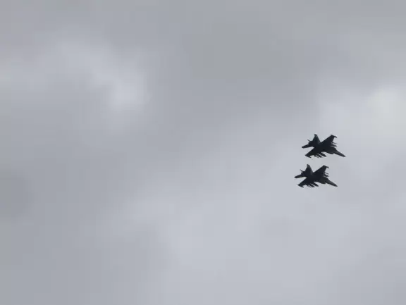 Historic resort with red turrets on foggy beach of fine white sand.