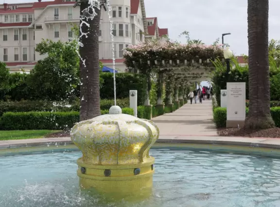 Historic resort with red turrets on foggy beach of fine white sand.