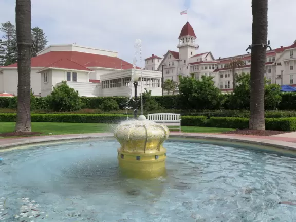 Historic resort with red turrets on foggy beach of fine white sand.