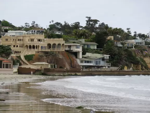 Beach with boardwalk, playground, magical mansion, and kayak rentals to kayak to sea caves, plus cafes nearby.