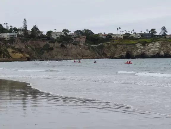 Beach with boardwalk, playground, magical mansion, and kayak rentals to kayak to sea caves, plus cafes nearby.