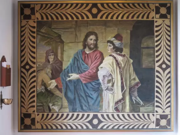 White-washed church with bell towers, rose window, Mary and contented baby Jesus sculpture.