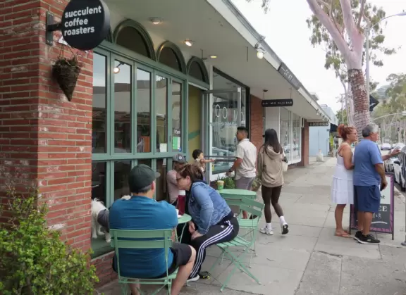 Fun beach with many spots to explore, including rock pools, a walking path with flowers above the sea, basketball courts, a playground, and a lawn by the beach.