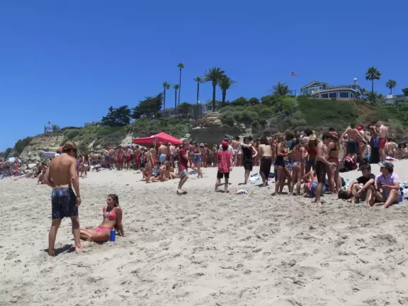 Gorgeous aquamarine water at a long strip of sand with a pier at the end.