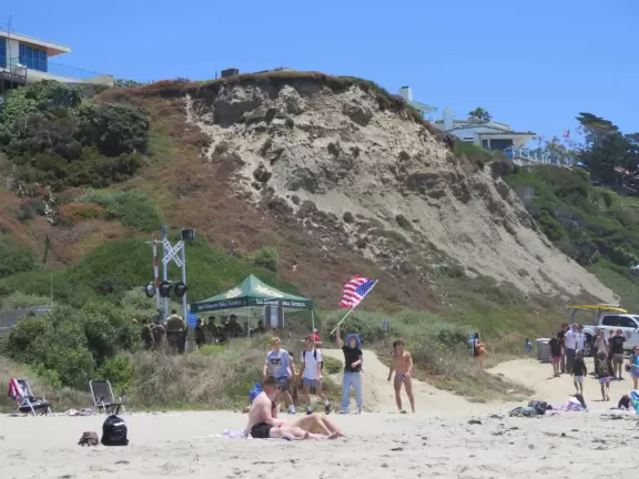 Gorgeous aquamarine water at a long strip of sand with a pier at the end.
