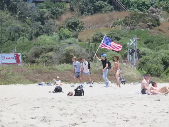 Gorgeous aquamarine water at a long strip of sand with a pier at the end.