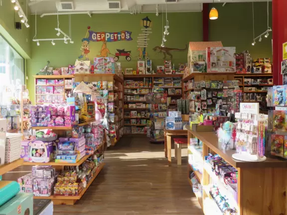 Shopping plaza with a deck offering lots of attractive public space, a trampoline for young kids, a sky deck bar, a dark public market with lights, cafes, stores and coffee shops.