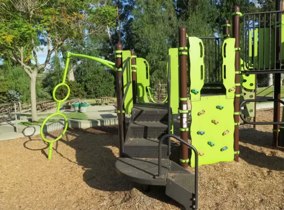 Neighborhood park with creek, eucalyptus trees and a small playground.