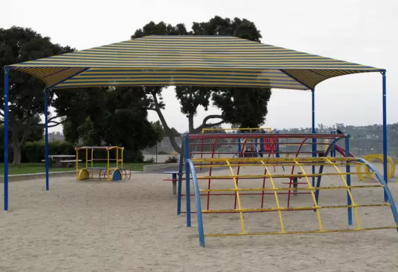 A large grassy stretch with an older playground and animal sculptures to climb.
