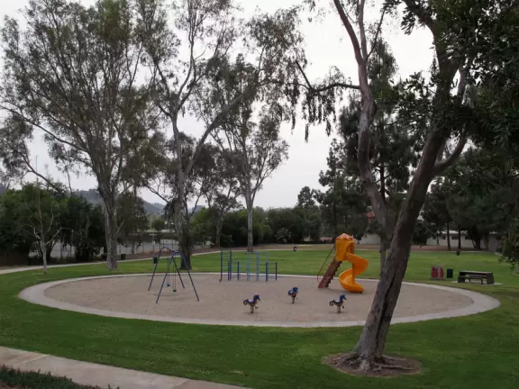 The lower play area, with sand, bouncies, swings, and curvy slide.
