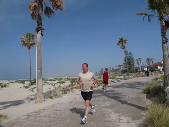 Historic resort with red turrets on foggy beach of fine white sand.
