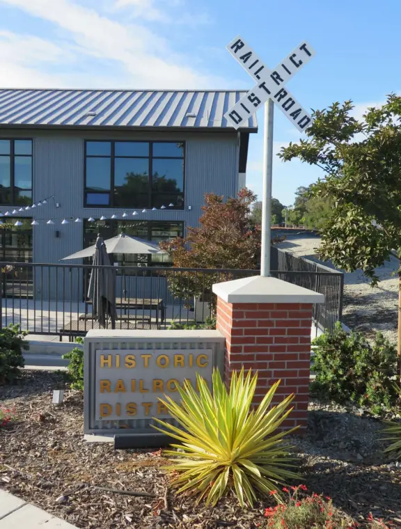 Trendy area with coffee shop, beer garden, wine bars, and cider bar, in industrial-style architecture with murals.