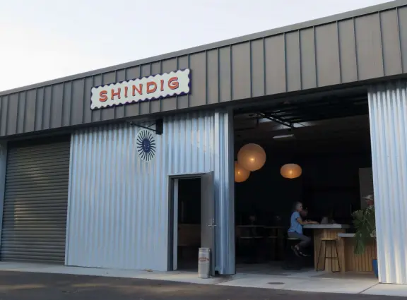 Trendy area with coffee shop, beer garden, wine bars, and cider bar, in industrial-style architecture with murals.