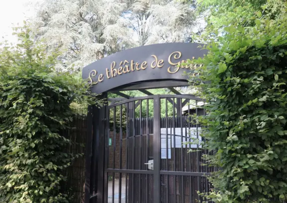 A beautiful park with a grand canal, an impressively high fountain, flower beds, a chateau, and the loveliest trees.