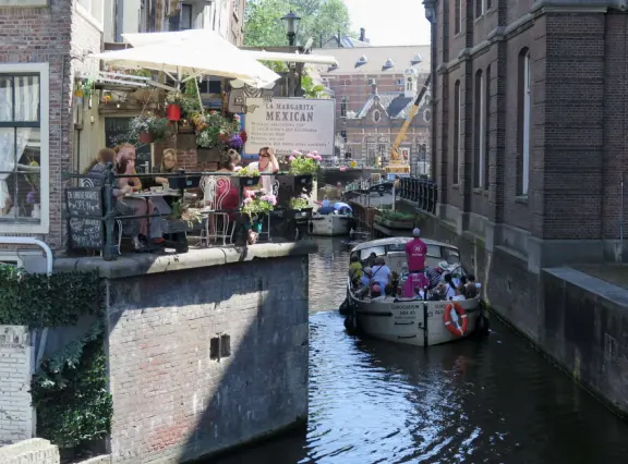 Flowers on bridges over canals, leafy outdoor seating at cafes, bustling streets, interesting museums, gingerbread architecture.