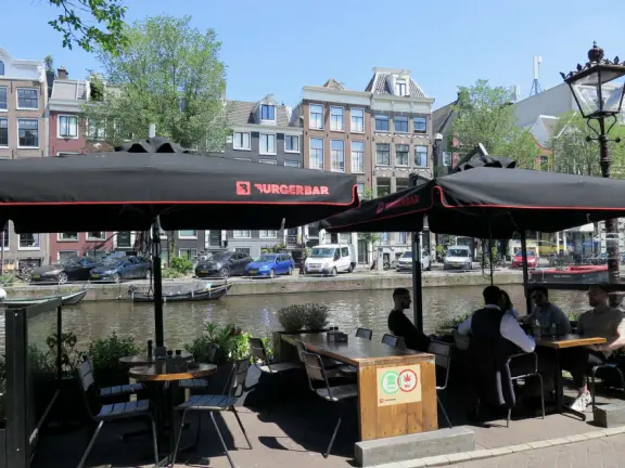 Flowers on bridges over canals, leafy outdoor seating at cafes, bustling streets, interesting museums, gingerbread architecture.