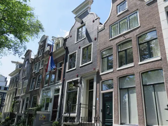 Flowers on bridges over canals, leafy outdoor seating at cafes, bustling streets, interesting museums, gingerbread architecture.