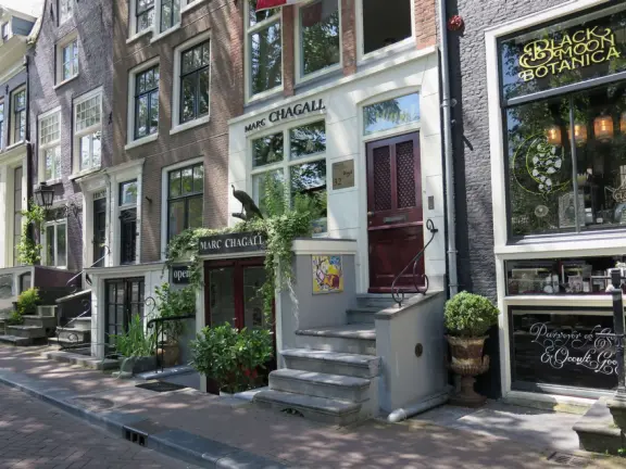 Flowers on bridges over canals, leafy outdoor seating at cafes, bustling streets, interesting museums, gingerbread architecture.