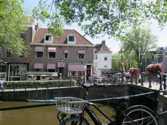 Flowers on bridges over canals, leafy outdoor seating at cafes, bustling streets, interesting museums, gingerbread architecture.