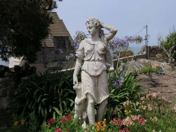 Half-timbered house over the ocean, with windmill and decorative lighthouse, and in summer, begonia house.