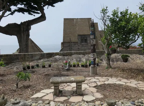 Half-timbered house over the ocean, with windmill and decorative lighthouse, and in summer, begonia house.