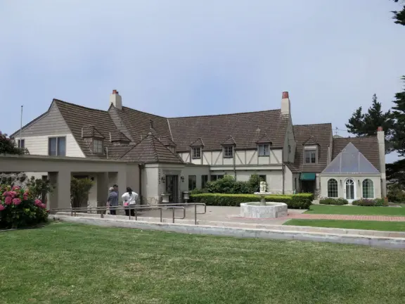 Half-timbered house over the ocean, with windmill and decorative lighthouse, and in summer, begonia house.