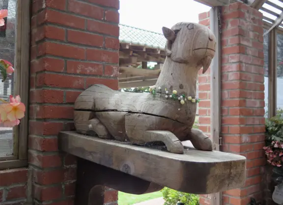Half-timbered house over the ocean, with windmill and decorative lighthouse, and in summer, begonia house.