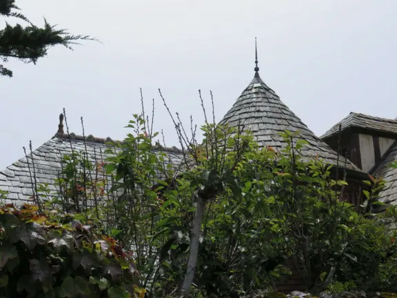 Half-timbered house over the ocean, with windmill and decorative lighthouse, and in summer, begonia house.
