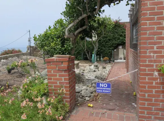 Half-timbered house over the ocean, with windmill and decorative lighthouse, and in summer, begonia house.