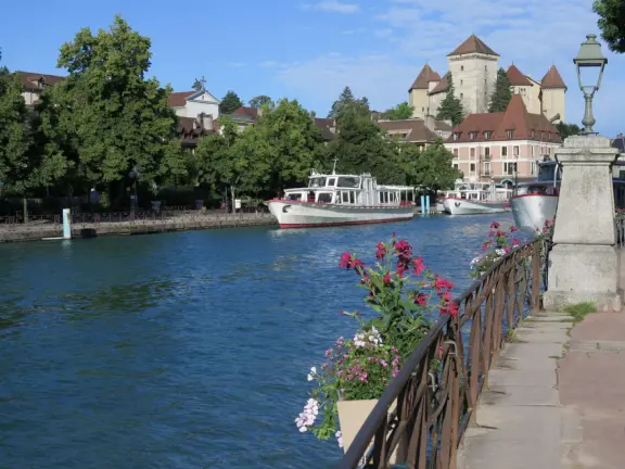 Lakeside park like an arboretum, with tall amazing trees from around the world, statues, modern art sculptures, stunning mountain views, ironwork lovers bridge, and promenade along the blue-green lake.