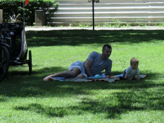 Lakeside park like an arboretum, with tall amazing trees from around the world, statues, modern art sculptures, stunning mountain views, ironwork lovers bridge, and promenade along the blue-green lake.