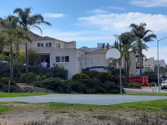 Mediterranean--style houses and basketball court. 
