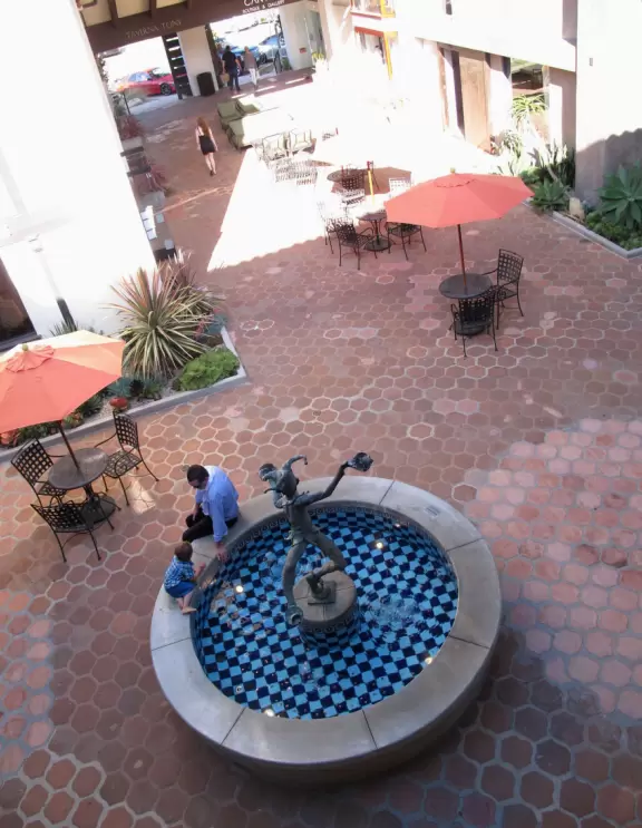 Popular outdoor mall with playground and sandpit, sculptures, picnic tables, toy store, and ritzy people!