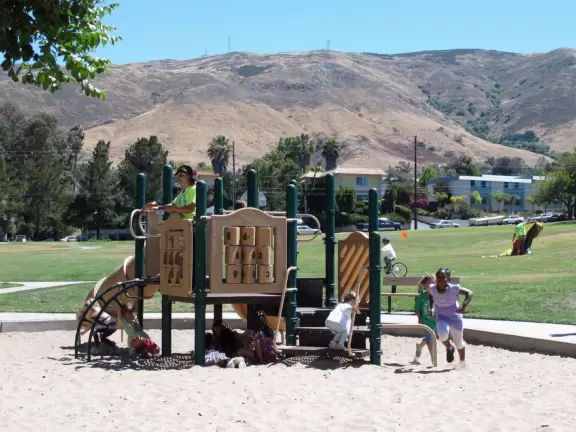 Neighborhood park with creek, eucalyptus trees and a small playground.