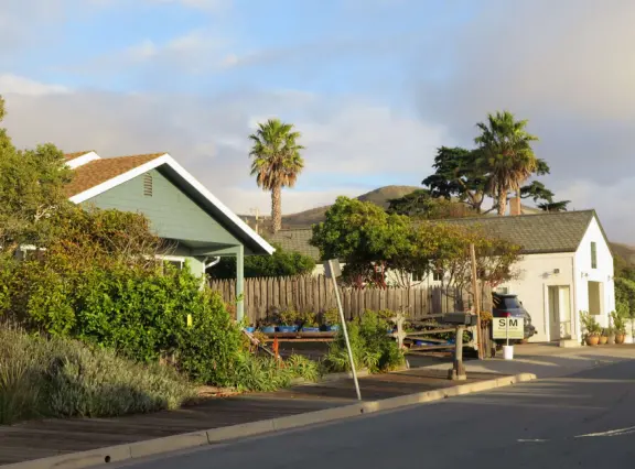 A pretty beachside town, with a wooden pier and wide windy beach with perfect views of Morro Rock, and colorful houses with gardens, backed by gently-sloping hills.